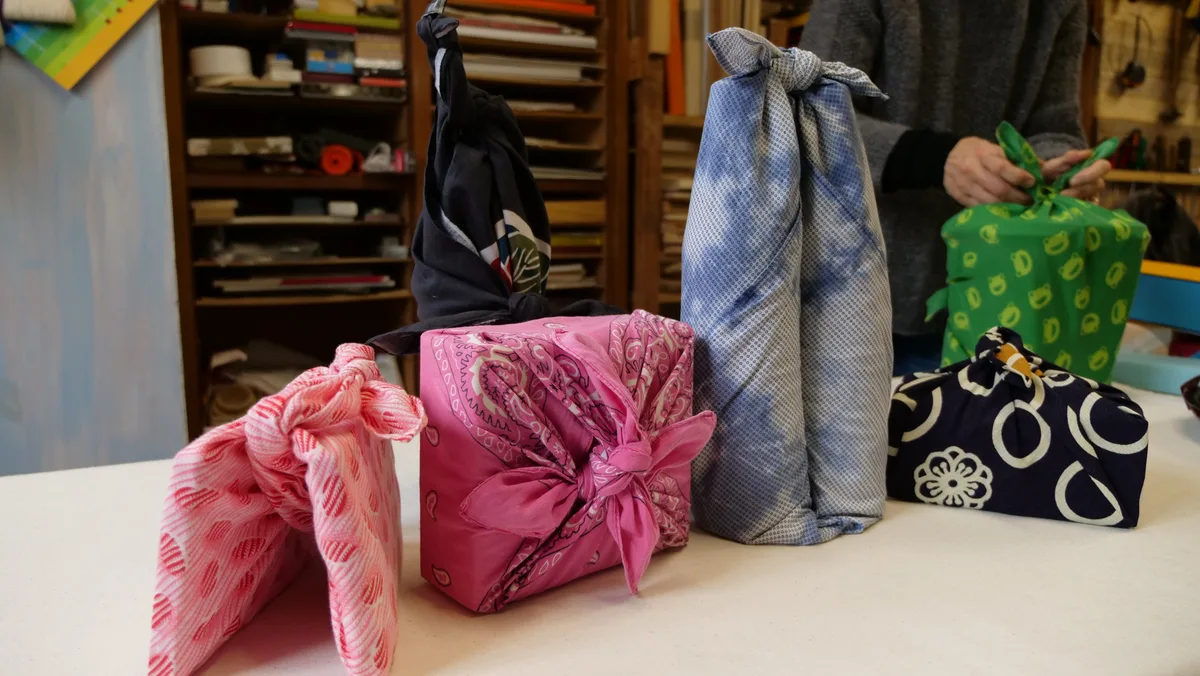 A collection of cloth-wrapped parcels in different sizes and patterns on a table.
